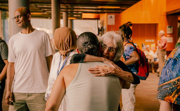 Two people hug in a friendly warm foyer at Cast in Doncaster.