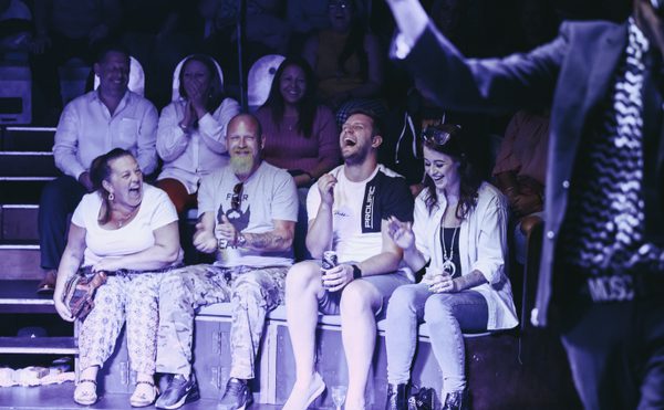 Audience members laughing at a performer on stage during Cast comedy club.