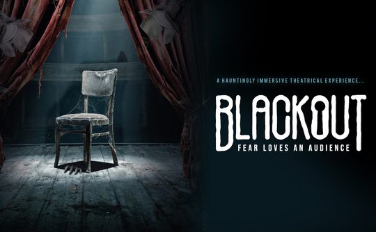 A dimly lit, worn-out chair on a wooden stage with dusty red curtains. Text reads "Blackout: Fear Loves an Audience." Eerie and suspenseful atmosphere.