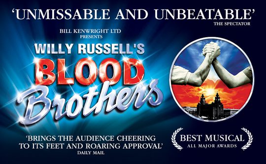 The shining words "Willy Russel's Blood Brothers" on a blue background. In a circle to right are two male arms clasping hands in front of a blue and red skyline.