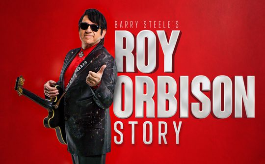 A person in a dark suit and sunglasses holds a guitar against a red background. Bold text reads "Barry Steele’s Roy Orbison Story." The mood is vibrant.