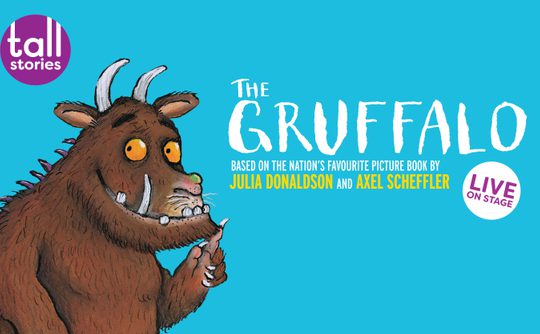 Illustration of the Gruffalo against a blue background with text promoting a live stage show. The Gruffalo has orange eyes and a friendly expression.