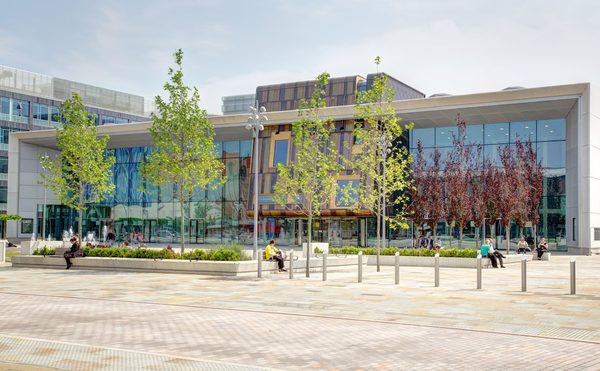 Cast building in the daytime, a wide angled shot across the square with green trees in the foreground